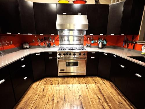 a kitchen with a stove and a wooden floor at The Crag On the Acadia National Park Border - Deck, Fire Pit, Steps to Trails in Otter Creek
