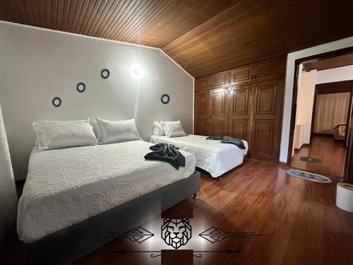 two beds in a room with wooden walls and wooden floors at Casa Hotel Imperion in Bogotá