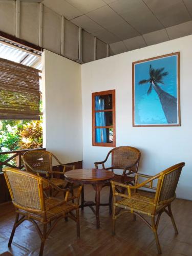a dining room with a table and chairs and a giraffe picture at Bunaken Sunrise Beach in Manado