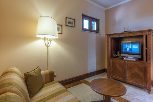 a living room with a couch and a television at Tmark Hotel Vaticano in Rome