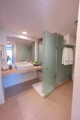 a bathroom with a sink and a large mirror at Aldea Thai Studios Steps to Beach and 5th Ave in Playa del Carmen