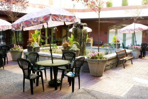a patio with a table and chairs and an umbrella at Harrison Lake Hotel in Harrison Hot Springs