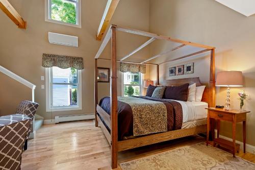 a bedroom with a canopy bed and windows at Captain Swift Inn in Camden