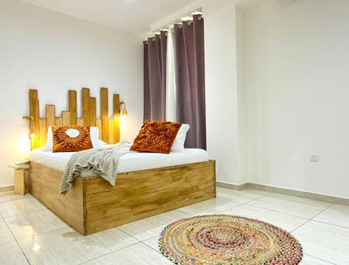 a bedroom with a wooden bed and a rug at Appartement spacieux La Vanille 2 in Ducos