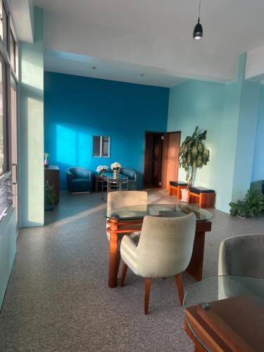 a living room with blue walls and a table and chairs at Coral Garden Hotel in Rota