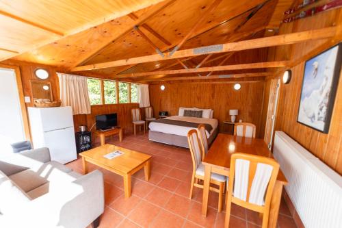 a living room with a bed and a table at Ngati Ruanui Mountain Lodge in Stratford
