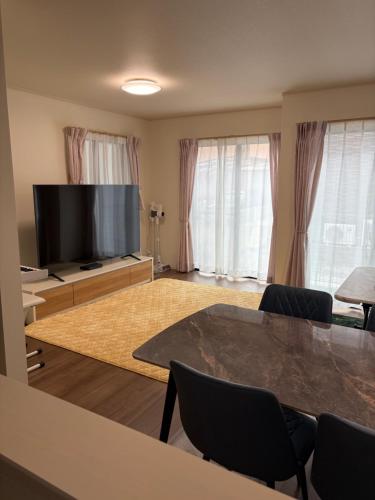 a living room with a flat screen tv and a table at Tokyo Koya Station on walk2mins新築別荘無料駐車場4LDK-free-wifi in Tokyo