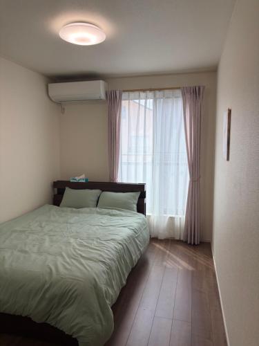 a bedroom with a bed and a window at Tokyo Koya Station on walk2mins新築別荘無料駐車場4LDK-free-wifi in Tokyo