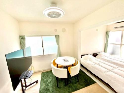 a bedroom with a bed and a table and chairs at LemonRooms in Aomori