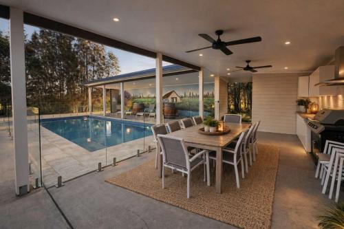 a kitchen and dining room with a table and a pool at Semillon Retreat in Pokolbin
