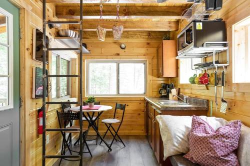 a tiny house with a kitchen and a table at Theodore Tiny Cabin- RRG Hot Tub Pet Friendly in Slade