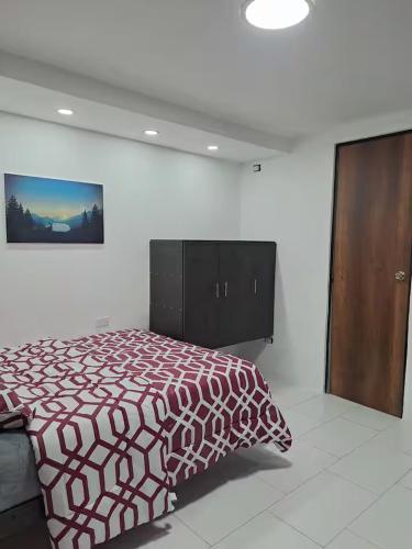 a bedroom with a bed and a wooden cabinet at Hotel Chemy in Quito