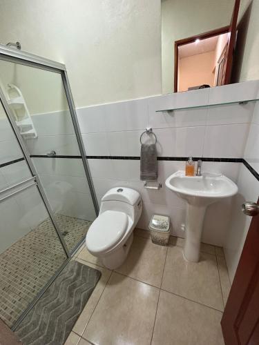 a bathroom with a toilet and a sink at Oasis House 2 in Tocumen