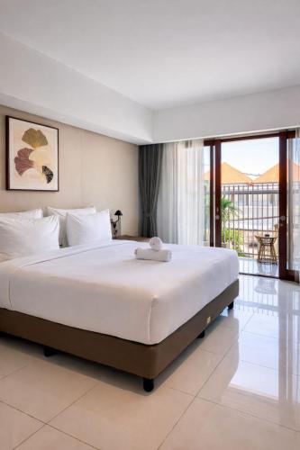 a bedroom with a large bed and a balcony at Royal Sweet By Sika in Canggu
