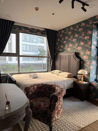 a bedroom with a bed and a chair and a window at 221B Baker in Ga Phú Văn