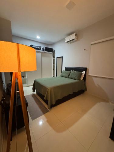 a bedroom with a bed and a lamp at Casa Belchior in Sobral