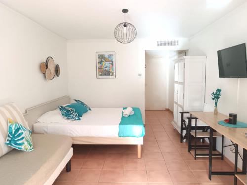 a living room with a bed and a table at Le Tropical in Sainte-Anne