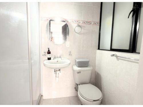 a white bathroom with a toilet and a sink at HOMSTY Escondite chido de Texmelucan in San Martín Texmelucan de Labastida