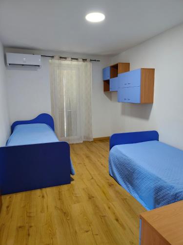 a bedroom with two beds and a wooden floor at Cascina Danila in Narzole
