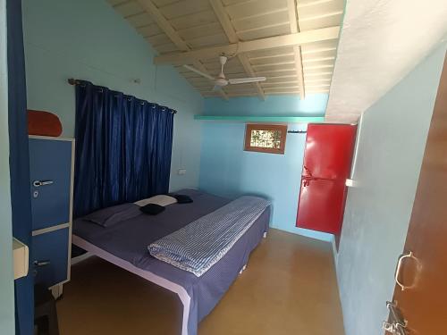 a small bed in a room with blue walls at Harender nayal homestay in Bhīm Tāl