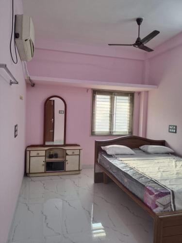 a bedroom with a bed and a dresser and a mirror at JPR Cottage in Erode