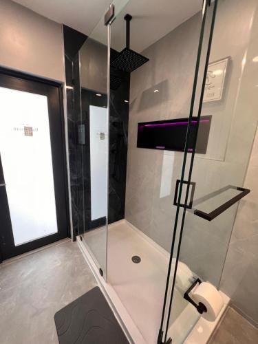a shower with a glass door in a bathroom at Fun n Chic house with pool in Miami in Golden Glades