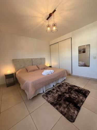 a bedroom with a large bed and a rug at BELLA VISTA - CAFAYATE in Cafayate