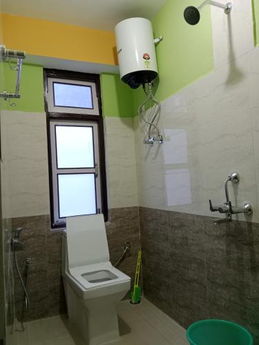 a bathroom with a toilet and a window and a shower at Hotel Sunrise in Lachen