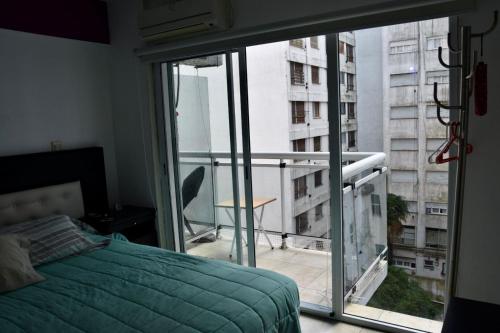 a bedroom with a bed and a balcony with a view at Mdp in Mar del Plata