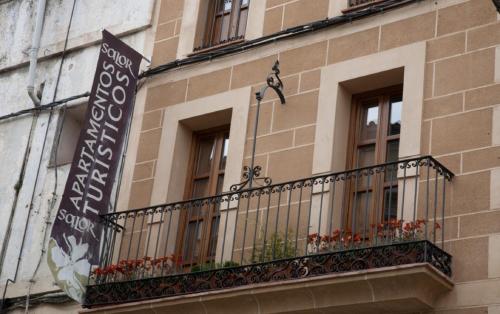 un edificio con un balcón con flores. en Hotel Alfonso IX en Cáceres