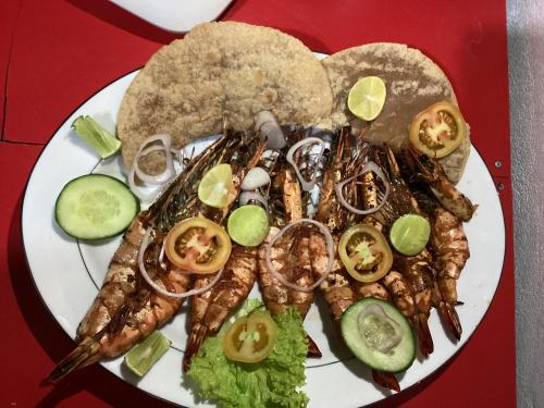 a plate of food with seafood on a red table at yashna villas in Pottuvil