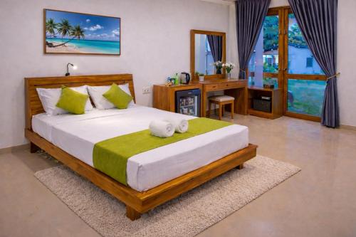 a bedroom with a large bed with a desk and a desk at yashna villas in Pottuvil