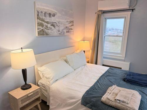 a bedroom with a bed with two lamps and a window at Ocean View Cozy Stay 4 in Hull