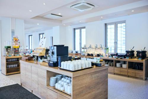 a large room with a counter with dishes on it at Centara Life Namba Hotel Osaka in Osaka