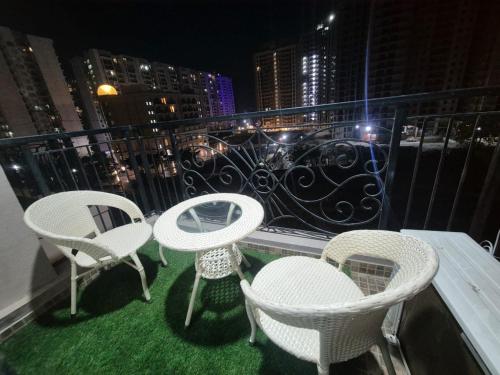 three chairs and a table on a balcony at night at RrHEAVENSTAY in Nalmatha