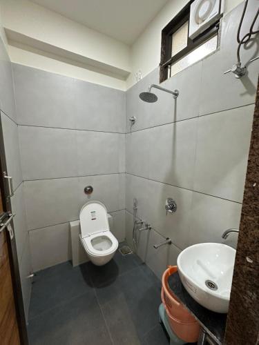 a bathroom with a toilet and a sink at Hotel Embassy Inn in Ānakhol