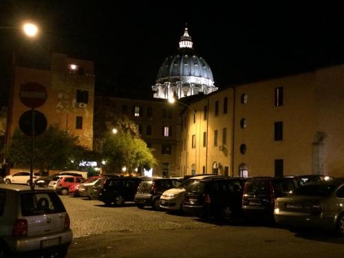 a parking lot with cars parked in front of a building at night at Argilla Apartment in Rome