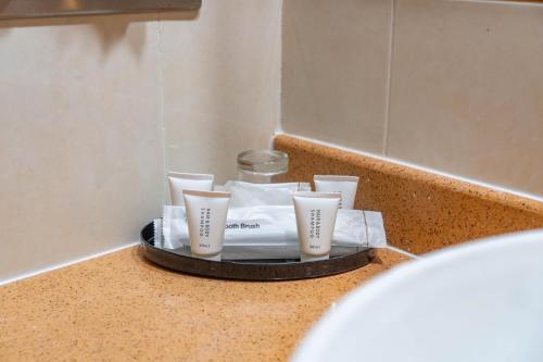 a tray with cups on a counter in a bathroom at Hotel Sandakan in Sandakan