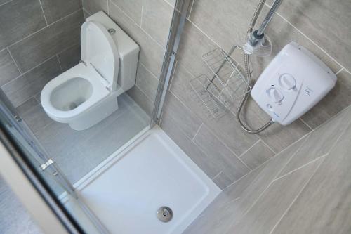 a small bathroom with a toilet and a shower at Kiloran Self Catering Suite in Skeabost