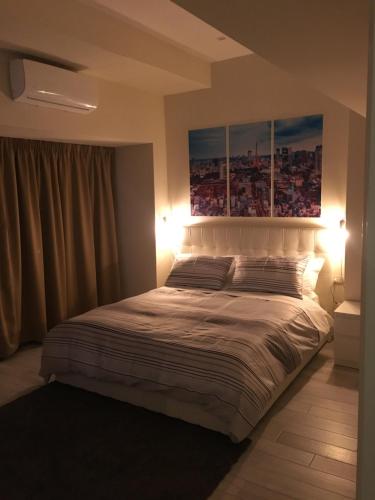 a bedroom with a bed with two paintings on the wall at Morra's Home in Naples