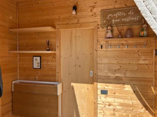 a wooden cabin with a sign on the wall at La Tiny du Clos Ernest in Cheminot