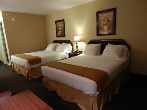 Habitación de hotel con 2 camas y 2 lámparas en Luxury Inn & Suites Troy en Troy