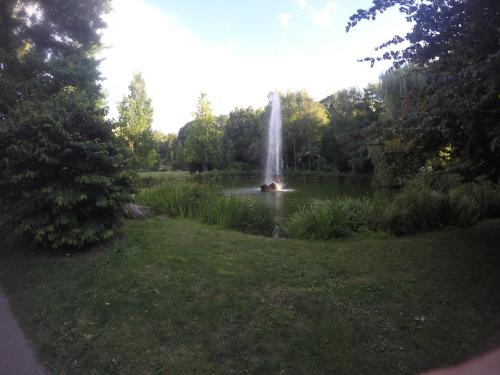 a fountain in the middle of a park with a pond at RUBY LODGINg in Banilad