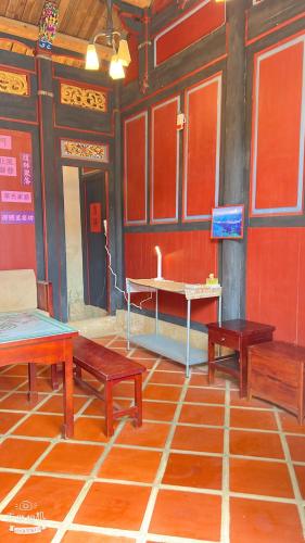 a room with three wooden benches and a table at 隆馨大悅古厝旅宿 in Jinhu