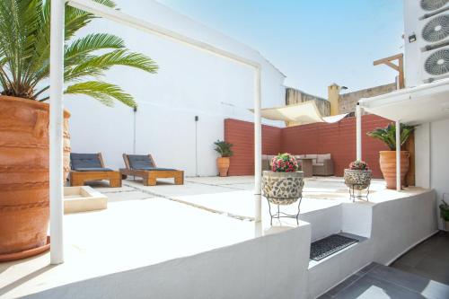 an outdoor patio with chairs and potted plants at Iriada House in Rhodes Town