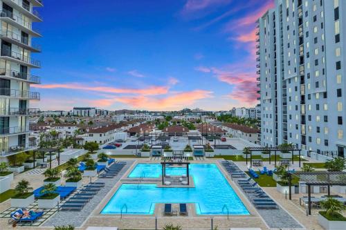 an overhead view of a pool with chairs and buildings at Modern Studio Pool View Downtown Doral' Heart in Miami