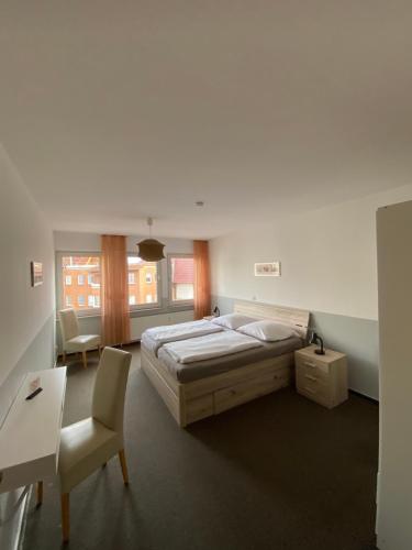a bedroom with a bed and a desk and a chair at Pension Zum Angestellten in Porta Westfalica