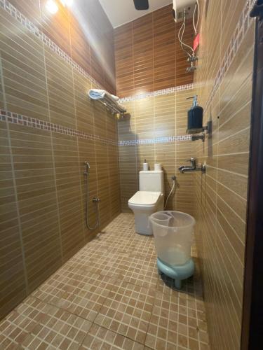 a small bathroom with a toilet and a shower at The Golden, Apartrooms in Trivandrum