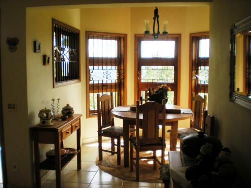 a dining room with a table and chairs and windows at Refúgio do Azzi in Monte Verde