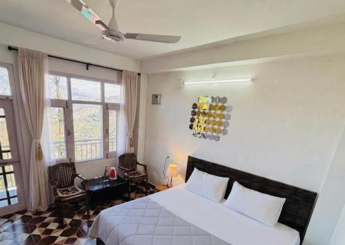 a bedroom with a large white bed and windows at Sunrise View Farm-stay -Narkanda in Shimla
